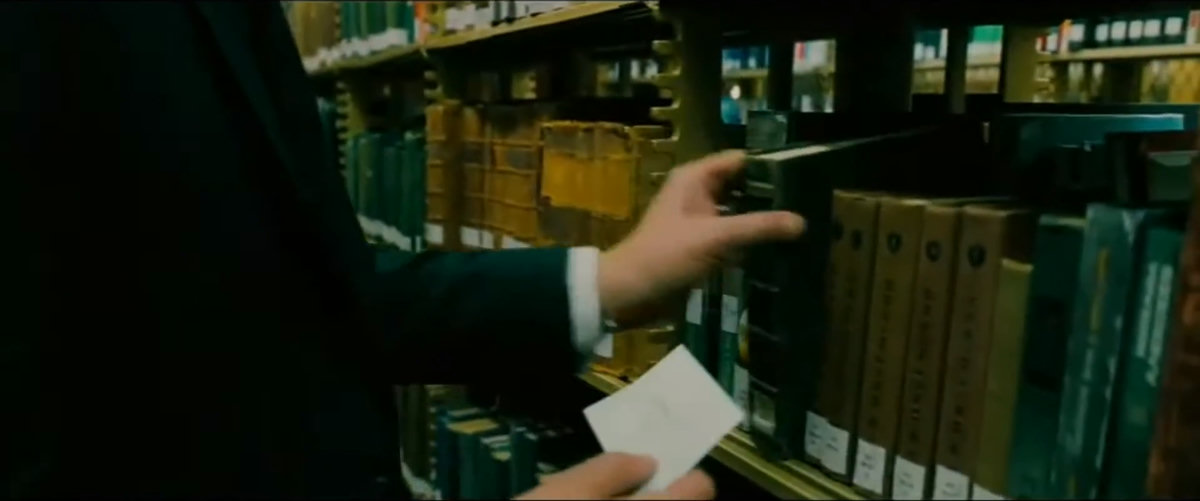 books, bookshelves, paper, window, tense, serious, focused, mysterious, standing, looking, searching, holding paper